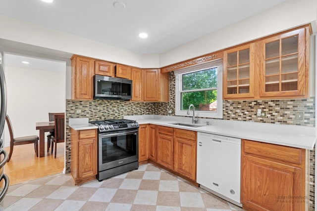 634 Primrose Ln, Schaumburg, IL 60194 - kitchen featuring appliances with stainless steel finishes, a sink, light countertops, light flooring, and glass insert cabinets