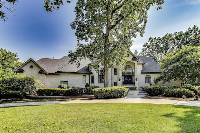 17N431 Oak Knoll Ln, Dundee, IL 60118 - french country home featuring a front yard, a chimney, and roof with shingles