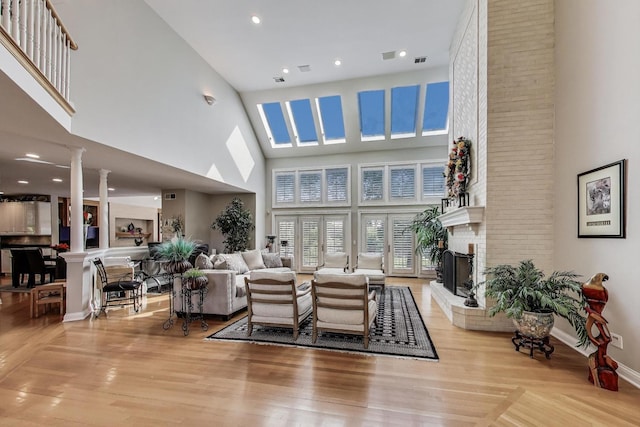 17N431 Oak Knoll Ln, Dundee, IL 60118 - living area featuring a towering ceiling, a brick fireplace, wood finished floors, decorative columns, and recessed lighting