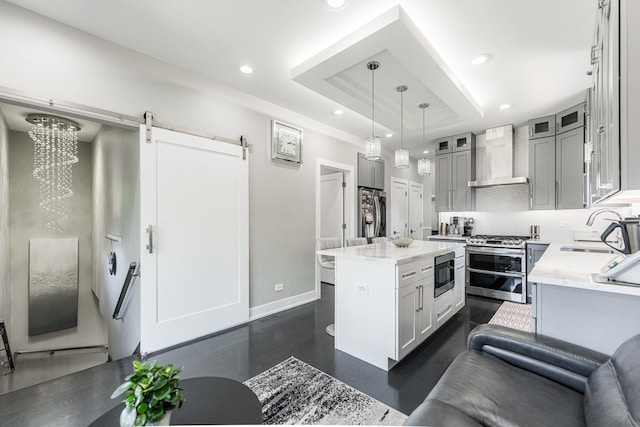 3800 N Oketo Ave, Chicago, IL 60634 - kitchen with appliances with stainless steel finishes, a sink, wall chimney range hood, a raised ceiling, and a barn door