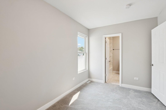 1508 N Lake Shore Dr, Round Lake Beach, IL 60073 - unfurnished bedroom featuring light carpet, baseboards, and ensuite bathroom
