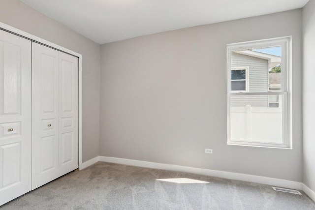 1508 N Lake Shore Dr, Round Lake Beach, IL 60073 - unfurnished bedroom featuring light carpet, baseboards, and a closet