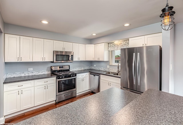 5008 W 122nd St Unit 2B, Alsip, IL 60803 - kitchen with appliances with stainless steel finishes, a sink, dark countertops, dark wood finished floors, and white cabinetry