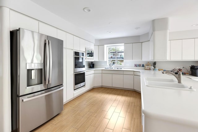 1452 Hemlock Knoll Ter, Northbrook, IL 60062 - kitchen featuring stainless steel appliances, a sink, light countertops, white cabinets, and light wood-style floors
