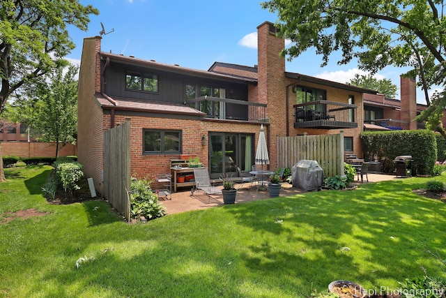 1704 Wildberry Dr Unit F, Glenview, IL 60025 - rear view of property with a chimney, a patio, and a yard