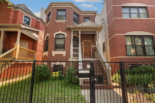 1828 N California Ave, Chicago, IL 60647 - view of front of house with brick siding, a fenced front yard, and a gate