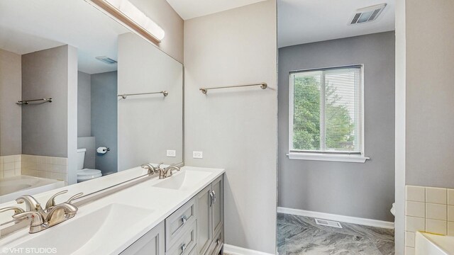 154 Wildflower Ln, Round Lake Beach, IL 60073 - full bath featuring toilet, marble finish flooring, a bath, double vanity, and baseboards