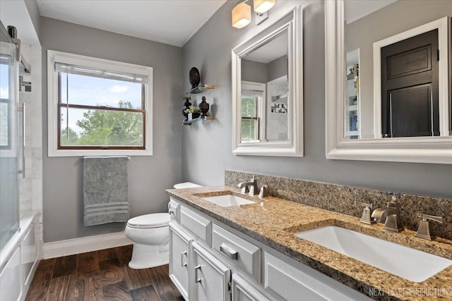 39W841 Prunetree Ln, Saint Charles, IL 60175 - bathroom featuring double vanity, toilet, wood finished floors, shower / bath combination with glass door, and baseboards