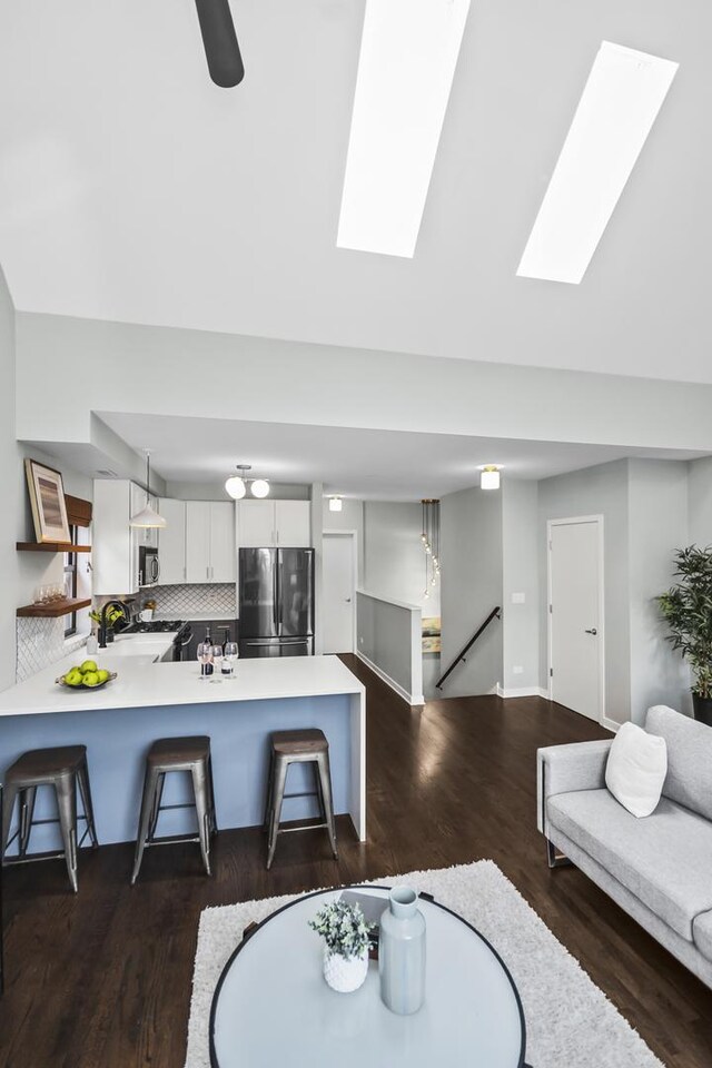 2035 W Crystal St Unit 3, Chicago, IL 60622 - living area featuring dark wood-style floors, a skylight, and baseboards