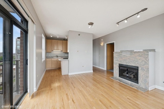 1529 S State St Unit 11B, Chicago, IL 60605 - unfurnished living room featuring track lighting, a sink, light wood finished floors, baseboards, and a fireplace