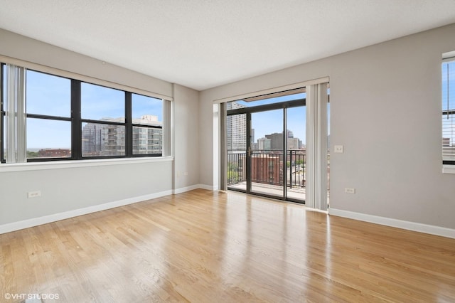1529 S State St Unit 11B, Chicago, IL 60605 - spare room with baseboards, healthy amount of natural light, wood finished floors, and a city view