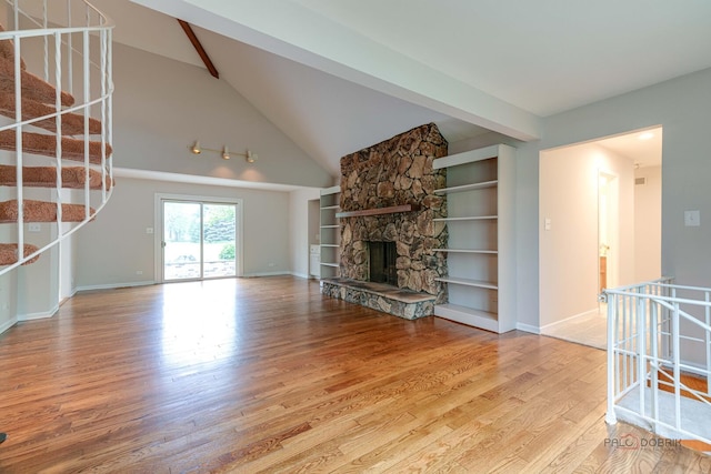 15 Highview Cir, Hawthorn Woods, IL 60047 - unfurnished living room with wood finished floors, a fireplace, vaulted ceiling, stairs, and baseboards