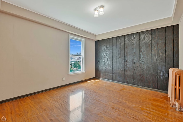 4042 N Kenneth Ave, Chicago, IL 60641 - empty room with radiator heating unit and wood finished floors