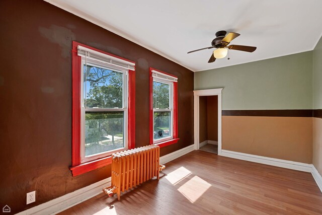 4042 N Kenneth Ave, Chicago, IL 60641 - empty room with radiator, wood finished floors, and a ceiling fan