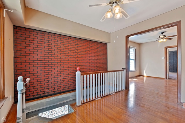 4042 N Kenneth Ave, Chicago, IL 60641 - hallway featuring brick wall, wood finished floors, and an upstairs landing