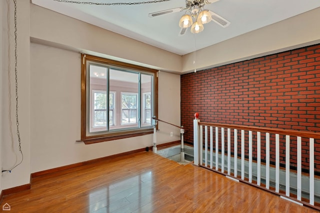 4042 N Kenneth Ave, Chicago, IL 60641 - spare room with wood finished floors, ceiling fan, and brick wall