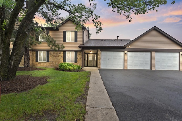 304 Memory Ln Unit 4, Westmont, IL 60559 - view of front of house with a garage, asphalt driveway, brick siding, and a yard