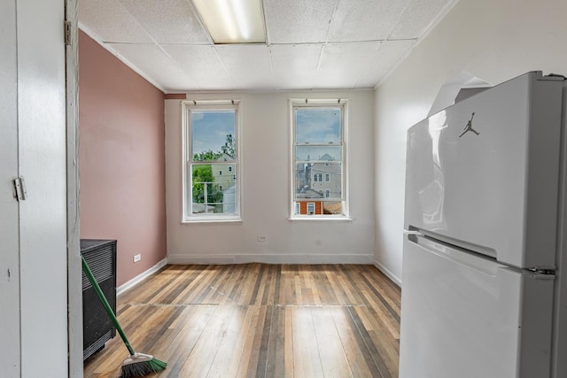 2653 W 21st St, Chicago, IL 60608 - unfurnished dining area with light wood-style floors, baseboards, and a drop ceiling