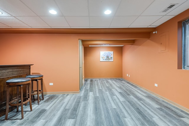 3018 Coastal Dr, Aurora, IL 60503 - finished below grade area featuring wood finished floors, a bar, a paneled ceiling, and electric panel