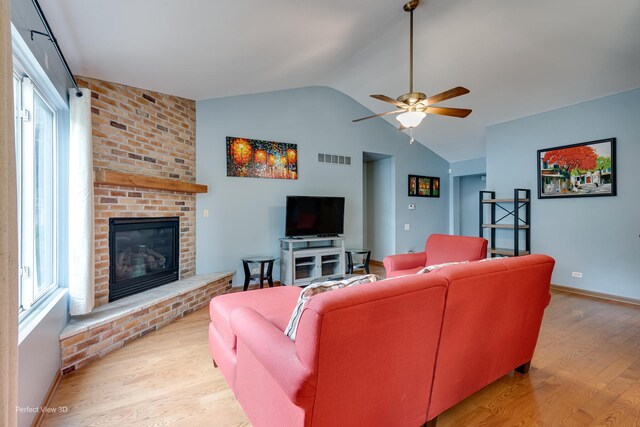 3018 Coastal Dr, Aurora, IL 60503 - living area featuring lofted ceiling, light wood-style flooring, a fireplace, and healthy amount of natural light