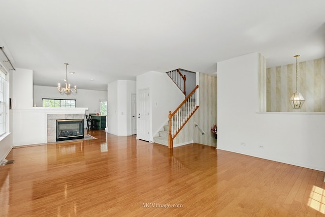 221 Willow Blvd, Willow Springs, IL 60480 - unfurnished living room featuring wood finished floors, stairs, a chandelier, and a fireplace