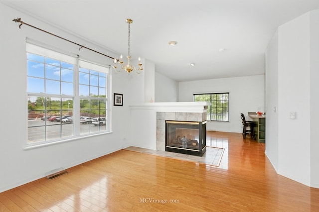 221 Willow Blvd, Willow Springs, IL 60480 - unfurnished living room with wood finished floors, a fireplace, a chandelier, and baseboards