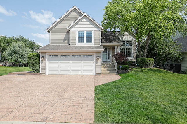 1703 Penny Ln, Bartlett, IL 60103 - tri-level home featuring a garage, a front lawn, and decorative driveway