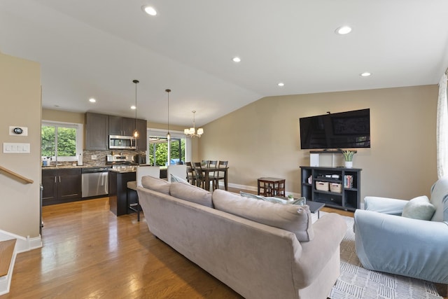 1122 N Cardinal Dr, Palatine, IL 60074 - living area with healthy amount of natural light, lofted ceiling, light wood-type flooring, a chandelier, and baseboards