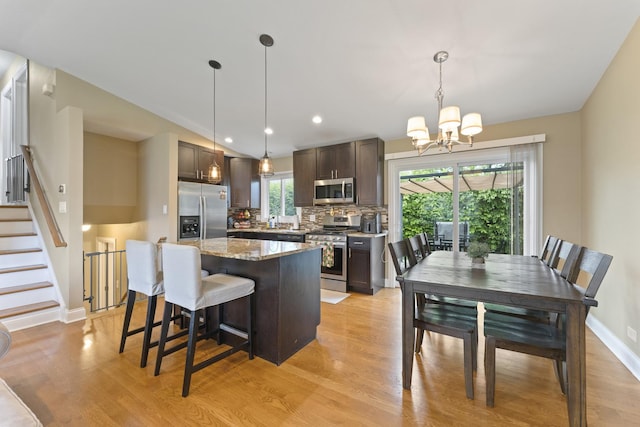 1122 N Cardinal Dr, Palatine, IL 60074 - kitchen featuring stainless steel appliances, dark brown cabinetry, a center island, a chandelier, and light wood finished floors