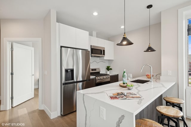 2342 W Adams St Unit 406, Chicago, IL 60612 - kitchen featuring stainless steel appliances, a peninsula, a sink, light wood-style flooring, and white cabinetry