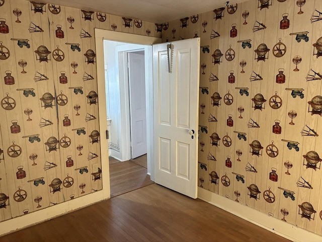 115 N Clay St, Mount Carroll, IL 61053 - empty room featuring wallpapered walls, dark wood-style flooring, and baseboards