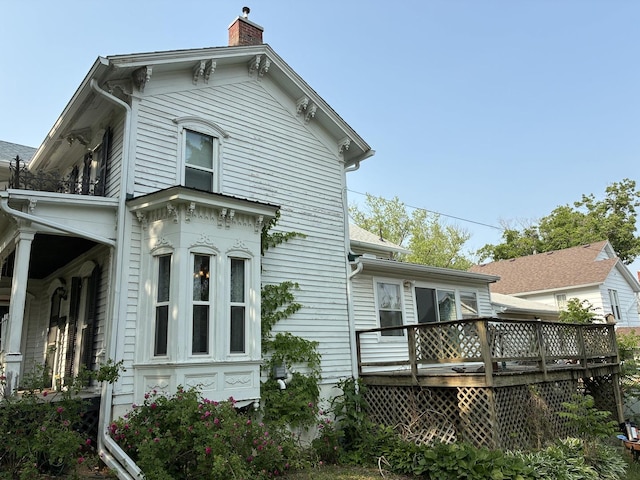 115 N Clay St, Mount Carroll, IL 61053 - rear view of house featuring a chimney and a deck