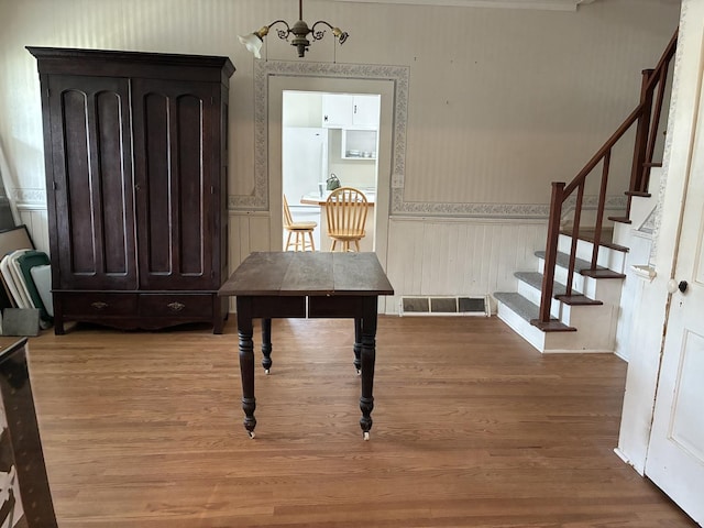 115 N Clay St, Mount Carroll, IL 61053 - dining area with wood finished floors, a wainscoted wall, and stairway