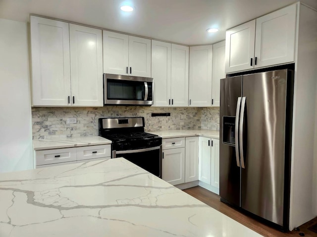 3601 W 123rd Pl, Alsip, IL 60803 - kitchen featuring stainless steel appliances, white cabinets, light stone counters, decorative backsplash, and recessed lighting