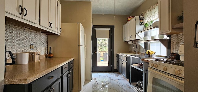 515 E Main St E, Amboy, IL 61310 - kitchen with white range with gas cooktop, light marble finish floors, decorative backsplash, and a sink