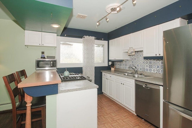 9204 Bumble Bee Dr Unit 1H, Des Plaines, IL 60016 - kitchen with appliances with stainless steel finishes, a sink, white cabinetry, and a kitchen bar