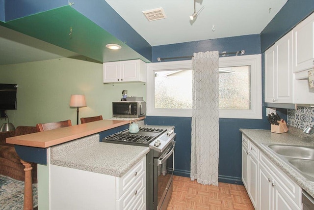 9204 Bumble Bee Dr Unit 1H, Des Plaines, IL 60016 - kitchen with appliances with stainless steel finishes, a sink, a breakfast bar area, and white cabinets
