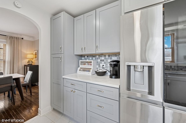 5146 N Mobile Ave, Chicago, IL 60630 - kitchen with stainless steel fridge with ice dispenser, arched walkways, decorative backsplash, light countertops, and gray cabinetry