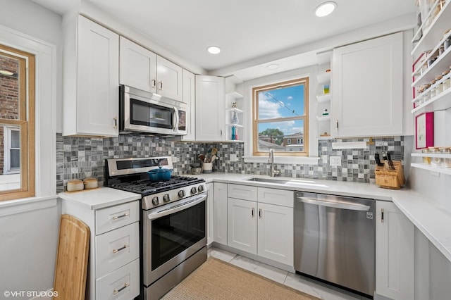 5146 N Mobile Ave, Chicago, IL 60630 - kitchen featuring stainless steel appliances, open shelves, a sink, white cabinetry, and decorative backsplash