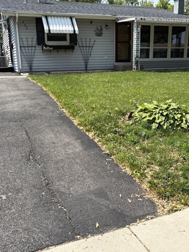 220 Harrison St, Carpentersville, IL 60110 - entrance to property with a lawn, a shingled roof, and a chimney