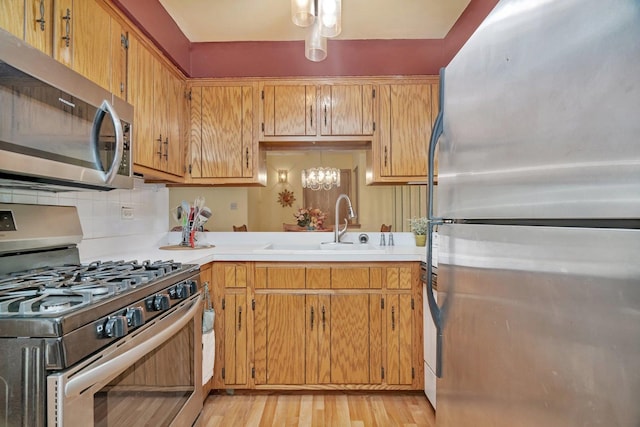 10528 Ridge Cove Dr Unit 11A, Chicago Ridge, IL 60415 - kitchen with appliances with stainless steel finishes, a sink, light countertops, decorative backsplash, and light wood-type flooring