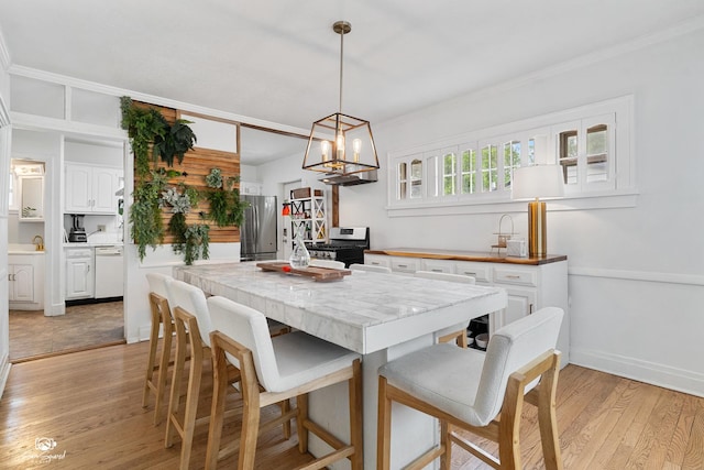 915 E Duane Blvd, Kankakee, IL 60901 - dining space with light wood-type flooring, a chandelier, and ornamental molding
