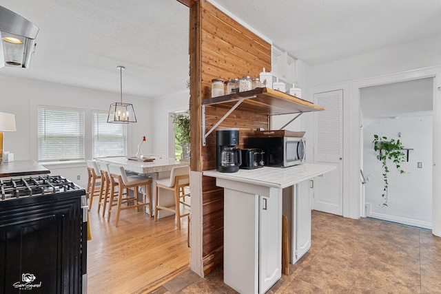 915 E Duane Blvd, Kankakee, IL 60901 - kitchen featuring black gas range oven, open shelves, stainless steel microwave, a chandelier, and light countertops