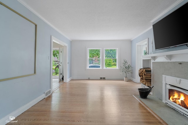 915 E Duane Blvd, Kankakee, IL 60901 - living room featuring a warm lit fireplace, light wood-style flooring, ornamental molding, and baseboards