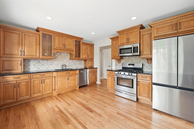 8306 Regency Ct, Willow Springs, IL 60480 - kitchen featuring appliances with stainless steel finishes, dark countertops, a sink, light wood-style floors, and recessed lighting
