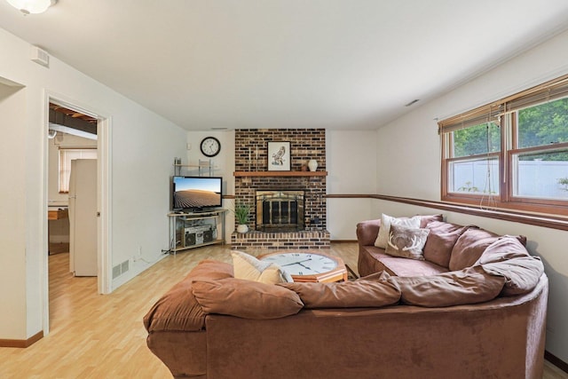 1705 N Donovan St, Mchenry, IL 60050 - living room with light wood-type flooring, a brick fireplace, and baseboards