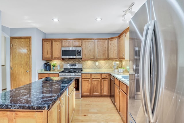 25911 W Highpoint Rd, Ingleside, IL 60041 - kitchen featuring stainless steel appliances, backsplash, light wood finished floors, a center island, and dark stone countertops