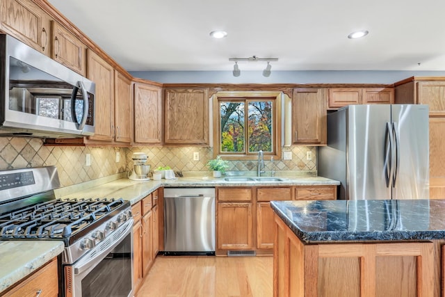 25911 W Highpoint Rd, Ingleside, IL 60041 - kitchen with appliances with stainless steel finishes, a sink, light wood finished floors, dark stone countertops, and decorative backsplash