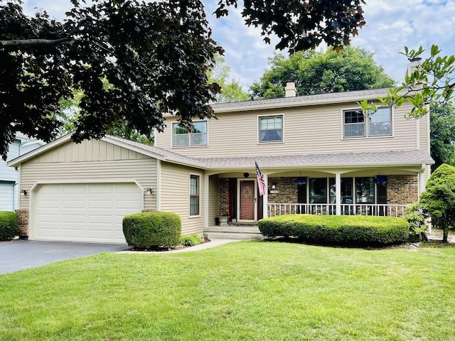 17581 W Summit Dr, Grayslake, IL 60030 - traditional-style house featuring asphalt driveway, an attached garage, a front yard, covered porch, and a chimney