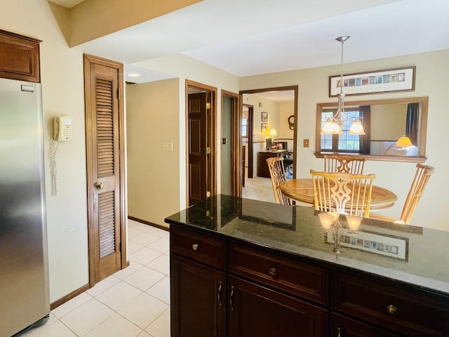 17581 W Summit Dr, Grayslake, IL 60030 - kitchen with stainless steel fridge, dark stone counters, light tile patterned floors, a chandelier, and decorative light fixtures